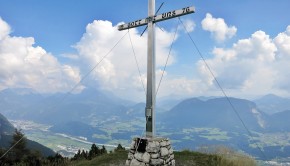 Das Gipfelkreuz des Köglhörndl mit Kaiser im Hintergrund