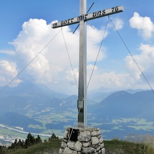 Das Gipfelkreuz des Köglhörndl mit Kaiser im Hintergrund